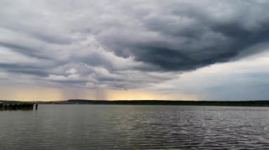 Gün batımında fırtınadan önce bir göl manzarasının zamanaşımı