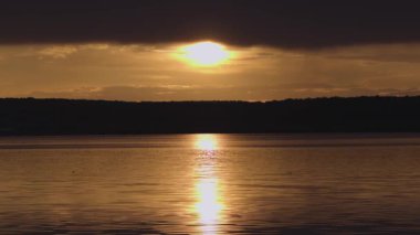 Yazın gün batımında fırtınadan önceki bir göl manzarası.