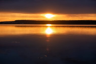 Yazın gün batımında fırtınadan önceki bir göl manzarası.
