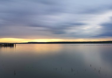 Yazın gün batımında fırtınadan önceki bir göl manzarası.