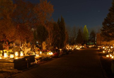 Gece Katolik mezarlığında mezar taşlarının üzerinde mumlar vardı..