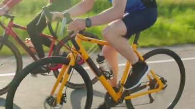 Spor elbiseli ve kasklı sarı bisikletli bir adam otoyoldaki kırmızı bisikletçiyi solluyor. Sıkı eğitim, rekabet ve hızlı yarış kavramı.