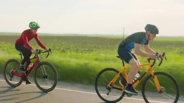 Anayol boyunca bisiklet süren özel spor ekipmanları giyen profesyonel bisikletçiler. İnsan kavramı, eğitim ve rekabet.