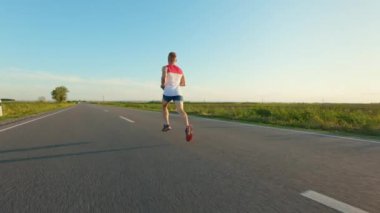 Sporcunun egzersiz, antrenman, antrenman ve sıcak yaz koşusunun arka görüntüsü. Sporcu maratona katılıyor, şort ve tişört giyiyor. Spor anlayışı ve sağlıklı yaşam tarzı.