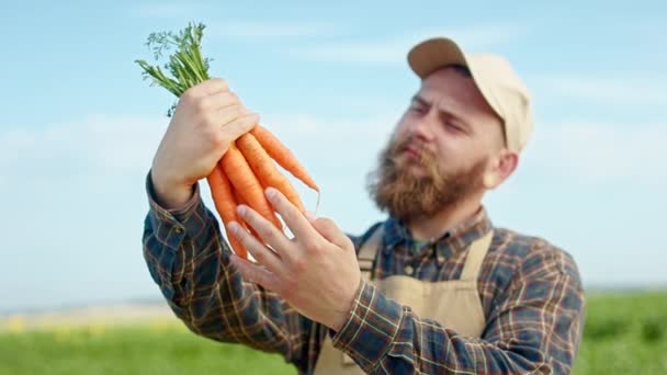 Вид Спереди Молодого Фермера Выращивающего Морковь Человек Бородой Держит Морковку — стоковое видео