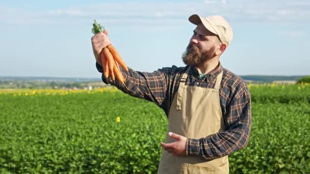 Вид Спереди Мужчины Фермера Стоящего Поле Держащего Морковь Показывающего Мужчина — стоковое видео