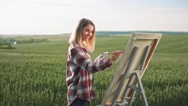 Vista Lateral Joven Artista Rubia Sosteniendo Pincel Pintura Dibujo Sobre — Vídeo de stock