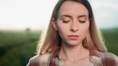 Baştan çıkarıcı, sarışın bir kadının açık havada kameraya bakıp düşünmesi. Çekici, ekose gömlek giyen, flört eden, poz veren genç bir bayan. Kadın güzelliği kavramı.