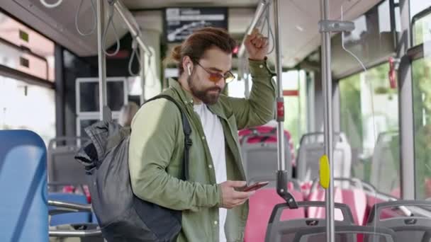 Widok Zajętego Człowieka Noszącego Plecak Okulary Przeciwsłoneczne Jadącego Autobusem Stojącego — Wideo stockowe