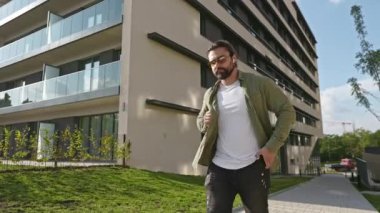 Ciddi, meşgul bir adamın caddede yürümesi, elinde tutması, akıllı telefon kullanması. Sırt çantalı esmer erkek, şık kıyafetler giyiyor. Kentsel yaşam tarzı kavramı.