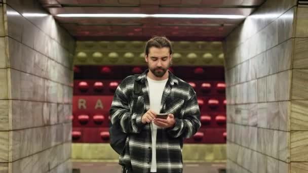 지하철에서 기다리고 대중교통 수단으로 여행하는 관광객들의 턱수염을 기르고 스마트폰을 사용하고 — 비디오