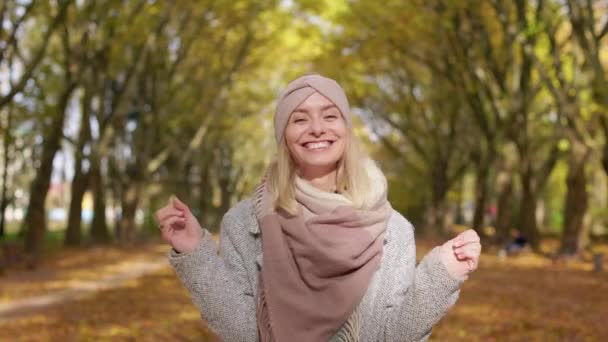 秋には公園を歩く幸せな 幸せな女性のフロントビュー 魅力的な 若い女性が立って カメラを見て ジャンプします 幸せと誠実な感情の概念 — ストック動画