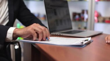 Close up of partners signing contract, making agreement in office. Businessman and businesswoman working in office, shaking hands each other. Concept of business and agreement.