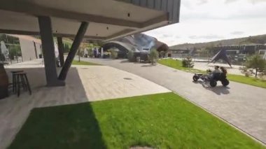 Back view of young couple driving buggy fast at resort. Two, beloved woman and man spending time together at nature, enjoying landscape and speed. Concept of active recreation.