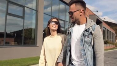 Side view of couple walking, holding by hands, sitting in buggy. Beloved and happy woman and man looking at each other, smiling, spending time together. Concept of active recreation.