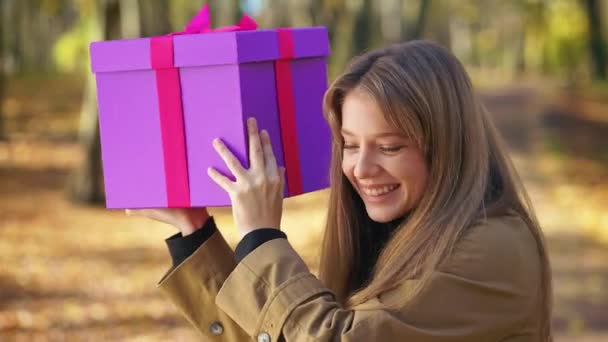 Side View Curious Young Lady Standing Park Shaking Present Gift — Vídeos de Stock