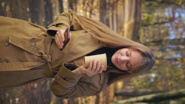 Parkta Duran Elinde Telefon Tutan Kitap Okuyan Gülümseyen Kadının Yan — Stok video