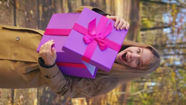 美丽的女士站在公园里 站在前面看风景 迷人的 年轻的女人拿着礼物 礼品盒 幸福与欢乐的概念 — 图库视频影像