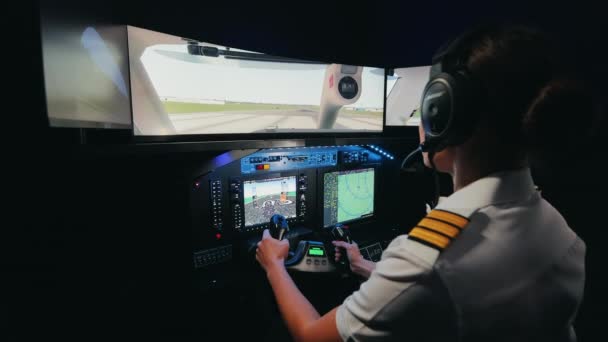 飛行機のキャビンに座っている女性のバックビューでは 制服や飛行機を着たかなりのパイロットは 飛行するために勉強し 航空機を発射する 飛行機による旅行の概念 — ストック動画