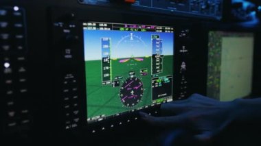 Close up of woman in uniform pressing, pointing buttons in cabin of airplane. Female pilot, stewardess sitting, looking at screen, launching plane. Concept of aviation and airplane.