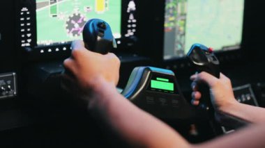 Kadın pilotun sandalyeye oturduğu, tuttuğu, döndüğü yakın plan. Üniformalı bir kadın ekrana bakıyor, uçağı fırlatıyor, meşgul, konsantre. Havacılık ve uçak kavramı.