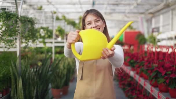 年轻的 女性花匠拿着水壶的前视图 迷人的 快乐的女士工作 站在温室里 种植和照料植物的概念 — 图库视频影像