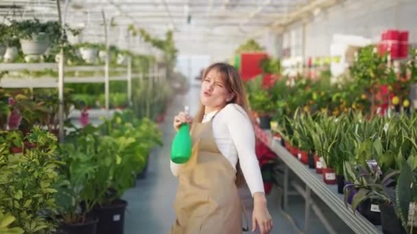 Framsidan Unga Kvinnliga Blomsterhandlare Innehav Flaska Besprutning Växter Attraktiv Glad — Stockvideo