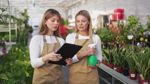 Genç Kadın Serada Çalışan Çiçekçiler Portakalcılık Üniforma Giyen Klasör Tutan — Stok video