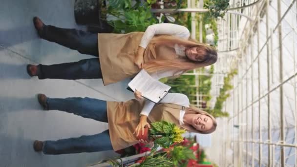陽気で面白い女性の花のダンスのサイドビュー お楽しみください エプロンを着て 植木鉢を持ち 植物を育てる美しい女の子 植物の栽培と管理の概念 — ストック動画