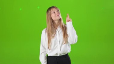 Stüdyoda kameraya bakan gülümseyen kadının ön görüntüsü. Güzel, sarışın bayan kameraya bakıyor, elini kaldırıyor, işaret ediyor. Mutluluk kavramı ve samimi duygular.