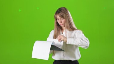 Meşgul, çalışkan, resmi kıyafetler giyen, ayakta duran, içeride poz veren bir kadının yan görüntüsü. Konsantre, odaklanmış, ayakta duran, klasörü tutan, okuyan bir kadın. Sıkı çalışma kavramı.