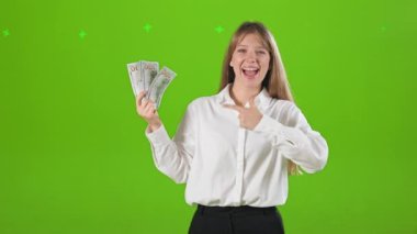 Başarılı, neşeli bir kadının stüdyoda poz verişinin yan görüntüsü. Sarışın, güzel bir kadın elinde para, para, gösteriş, işaret. Mutluluk ve başarı kavramı.