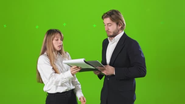 スタジオに立ってビジネスパートナーの側のビュー 話して かなりの女性とハンサムな男が公式服を着ている 緑のスタジオを背景に孤立 — ストック動画
