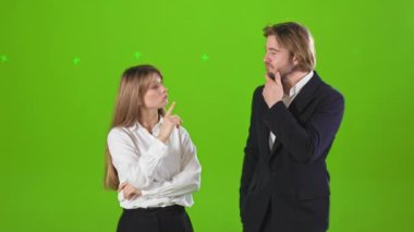 Stüdyoda durup birbirlerine bakan iş ortaklarının yan görüntüsü. Çekici bir kadın ve yakışıklı bir erkek resmi kıyafetler giyiyor. İş ilişkileri kavramı.