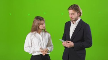 Stüdyoda para ile poz veren genç işadamı ve iş kadınının yan görüntüsü. Yakışıklı adam güzel bir kadına para veriyor, gururlu, zengin. Para ve başarı kavramı.