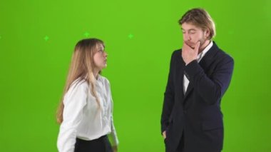 Stüdyoda genç bir kadınla bir adamın tartıştıklarını gördüm. Genç bir bayan ağlıyor, titriyor, yakışıklı bir adamla kavga ediyor, kızgın. Yeşil stüdyo arka planında izole edilmiş..