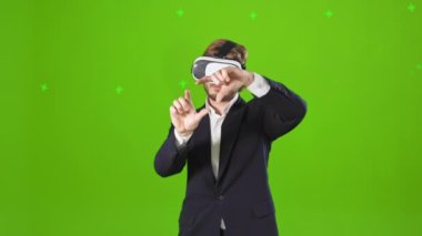 Sanal gözlük takan bir adamın ön görüntüsü. İzliyor, bakıyor, gösteriyor. Genç erkek, ayağa kalkıyor, ellerini uzatıyor, işaret ediyor. Modern yaşam tarzı ve gerçeklik kavramı.