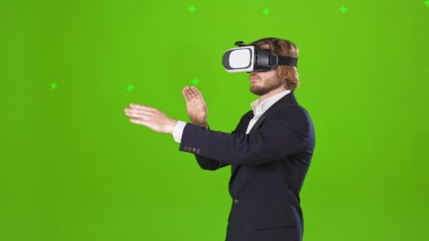 仮想メガネで現実を見て若い ハンサムな男の側のビュー 男性の衣装やシャツを着て 手を伸ばし スクロールします 緑のスタジオを背景に孤立 — ストック動画