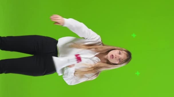 严肃的金发女人做停止动作 一边用扩音器对着摄像机大喊 前视自信的女性穿着与扬声器衬衫 用手停下来 隔离在绿色 手势概念 — 图库视频影像