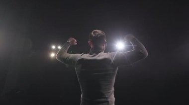 Sahnedeki iş konferansı sırasında olumlu duygularını ifade ettiği için yumruklarını sıkarak hareketler yapan enerjik iş adamı. Halkın kavramı, zafer ve motivasyon.