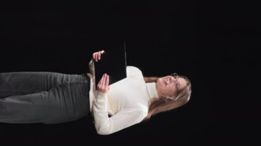 Beyaz kadın işletme koçunun konferansta bilgi alışverişi yaparken kulaklık ve pano kullandığı dikey bir video. İnsan kavramı, sunum etkinliği ve eğitim.