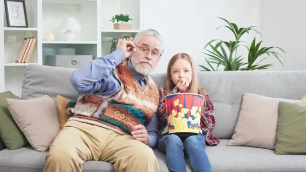 Biały Dziadek Wnuczka Oglądają Horror Telewizji Jedzą Razem Popcorn Domu — Wideo stockowe