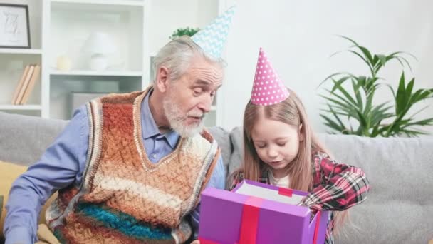 Close Curious Granddad Grandchild Sitting Grey Sofa Opening Wonderful Gift — Stock Video