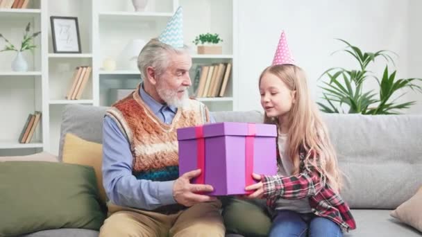 Zorgvuldige Grootvader Geeft Grote Paarse Geschenkdoos Aan Kostbare Kleinkind Tijdens — Stockvideo