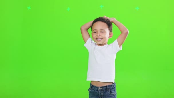 喜欢可爱的男孩儿穿着T恤 举起胳膊 在工作室里感到快乐 眼前的景象是快乐的非洲裔美国男孩举手投足 与绿色隔离 摆出相机的姿势 情感概念 — 图库视频影像