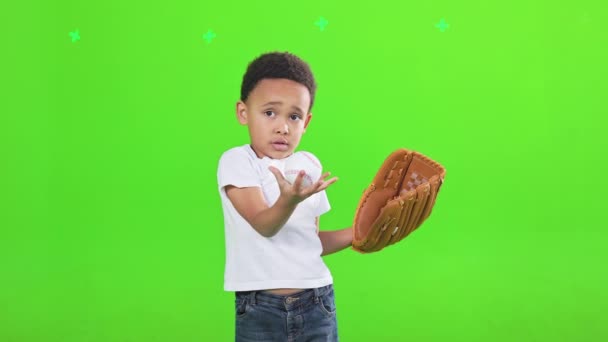 混淆不清的年轻的非洲裔美国男孩与棒球手套打与白色球里面 认真可爱的垒球运动员摆姿势与球 期待相机 隔离在绿色 体育概念 — 图库视频影像