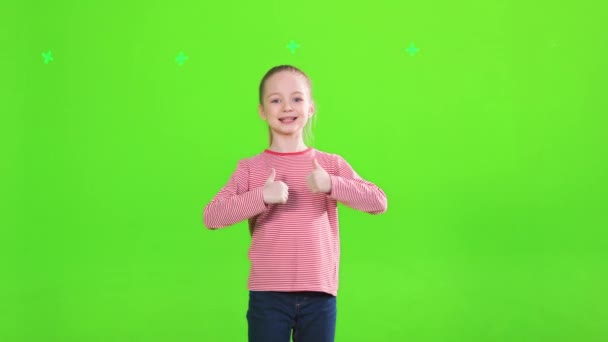블라우스 엄지손가락을 스튜디오 미소짓는 아이가 긍정적 손동작을 바라보는 앞쪽의 배경에 — 비디오