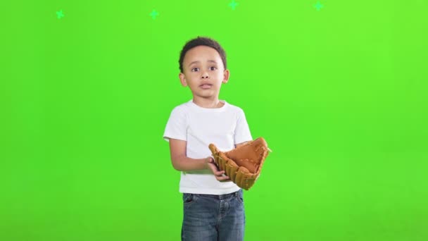 专注的小非洲裔美国男孩穿着棒球手套在工作室接球 前看集中的男孩在T恤打垒球 孤立在绿色 体育概念 — 图库视频影像