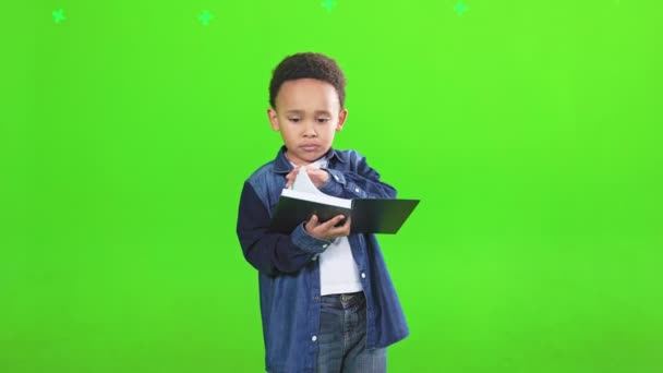 Ciekawy Afrykański Chłopiec Czytający Książkę Studiu Widok Przodu Skupiony Chłopiec — Wideo stockowe