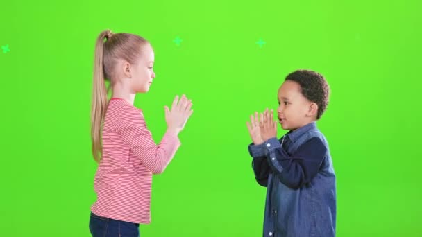 快乐的高加索女孩和非洲裔美国可爱男孩拍手叫好 从侧面看快乐的孩子们穿着休闲装在一起玩耍 给人一种很高很孤独的感觉 童年的概念 — 图库视频影像